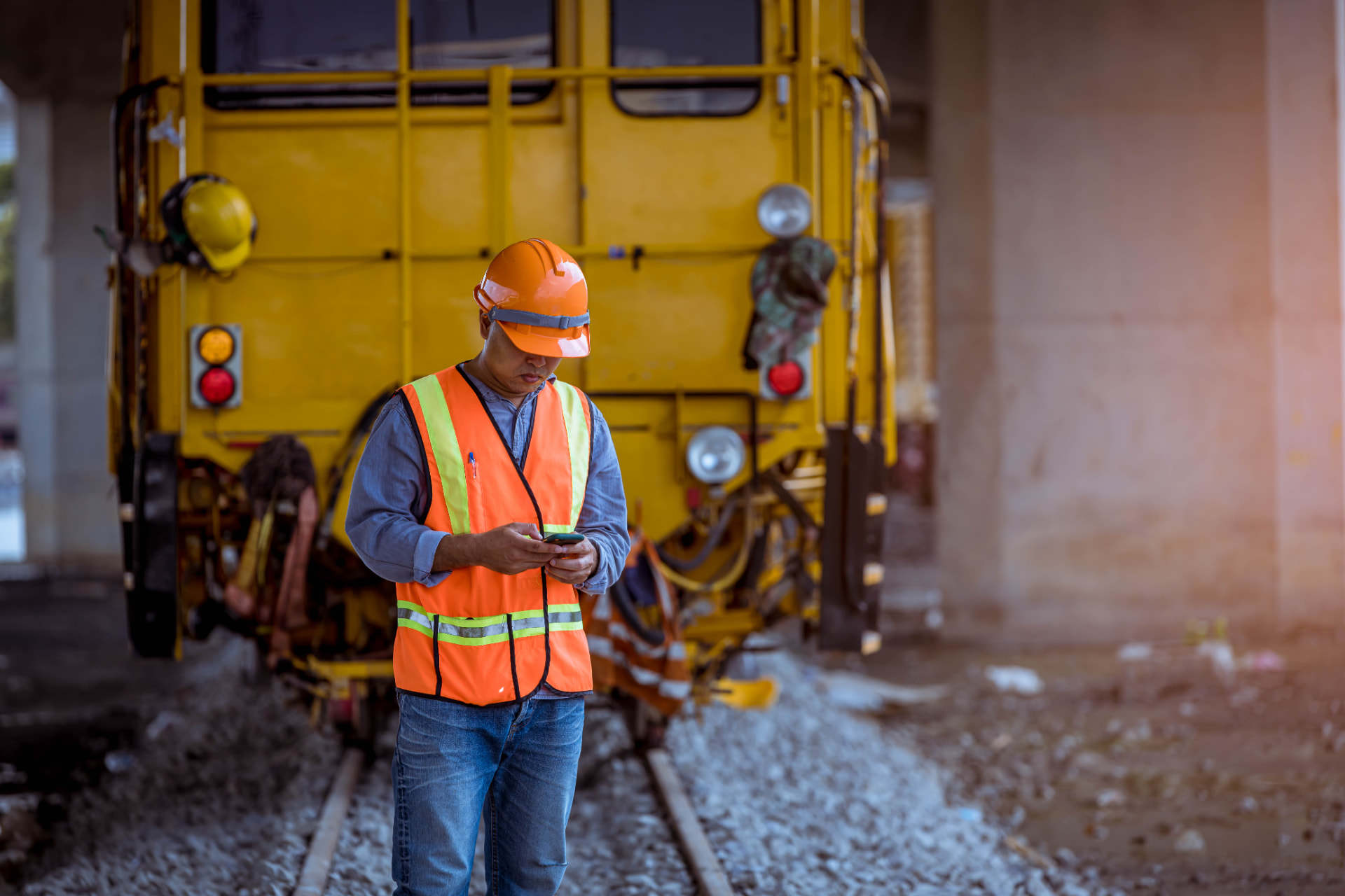 Railway engineer in high-visibility clothing inspecting a train