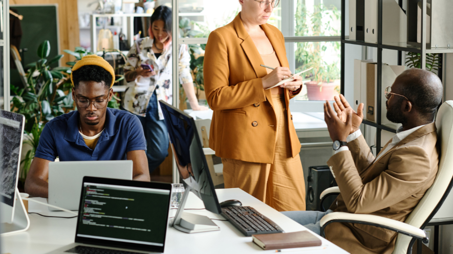 Colleagues collaborating around a desk in a bright office